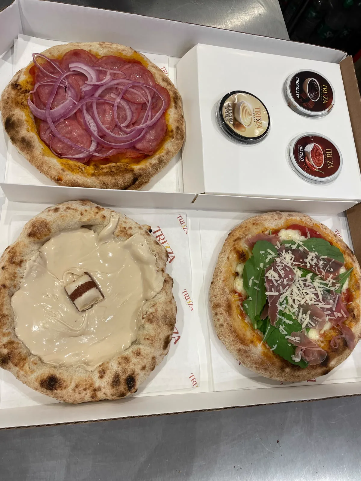 Caixa Tri3za com três pizzas e três molhos pronta para compartilhar